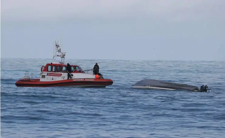 A coastguard boat with the capsized boat off Kaikoura