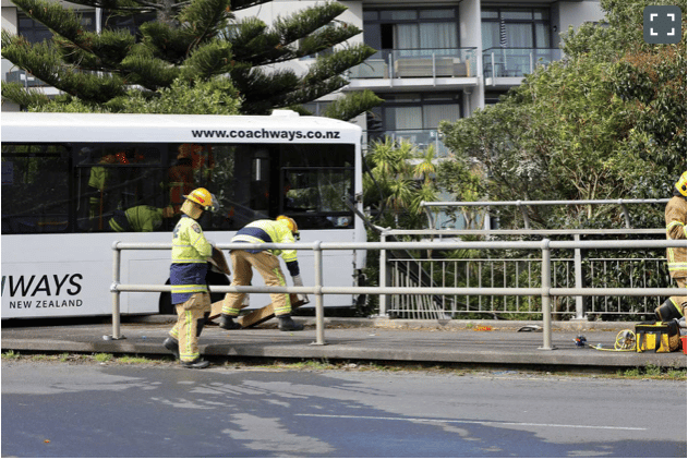 Firefighters can be seen moving the bus back on the footpath