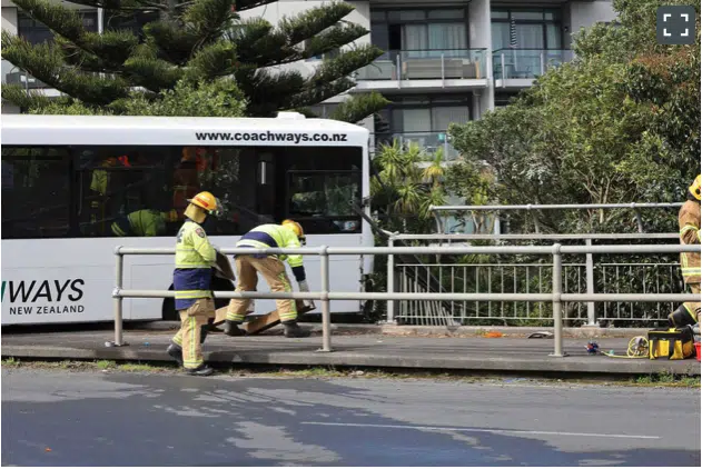 Firefighters can be seen moving the bus back on the footpath