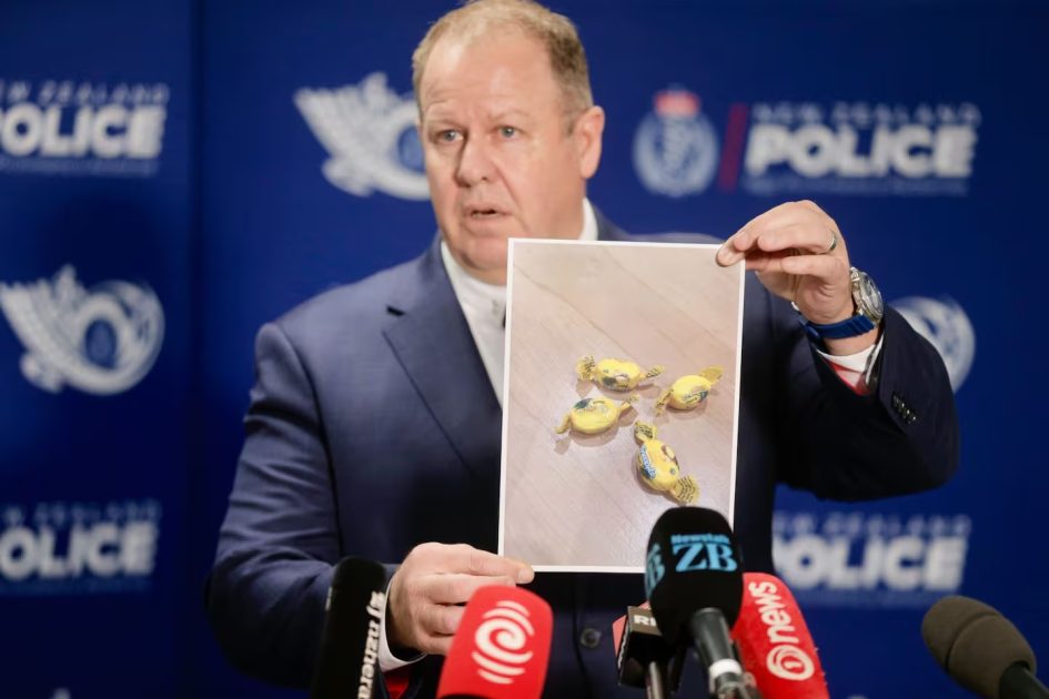 Detective Inspector Glenn Baldwin holds up a photo of the Rinda-branded meth-laced lollies found in food parcels given to needy families