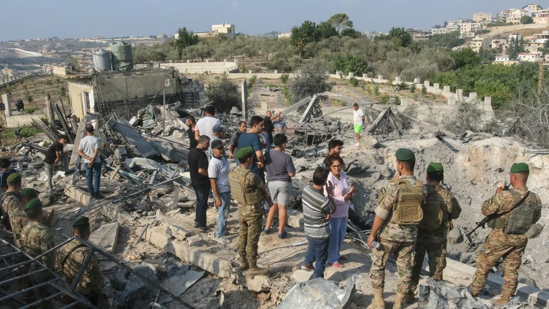 Lebanese soldiers and local residents stand at the site of an Israeli airstrike in the southern Lebanese village of Toura on Thursday, November 6.