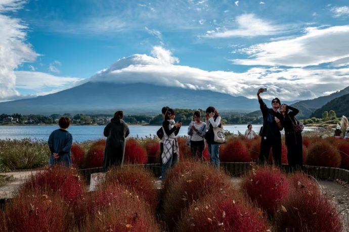 Tourists take pictures near Japan's Mount Fuji last month