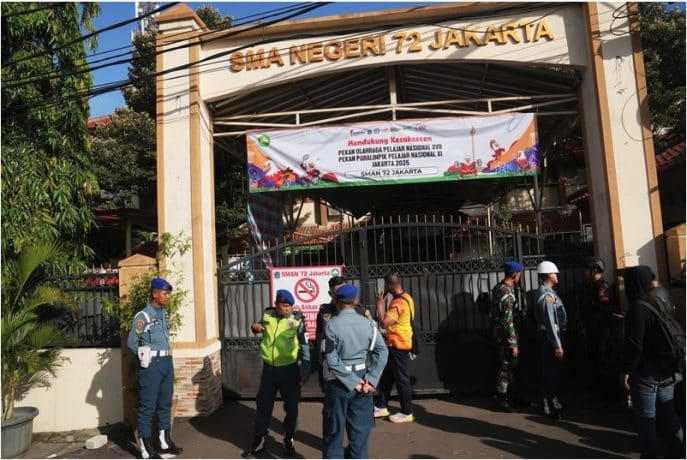 Police officers and military personnel stand guard at the gate of a school where explosions reportedly occurred in Jakarta Indonesia Friday Nov. 7 2025