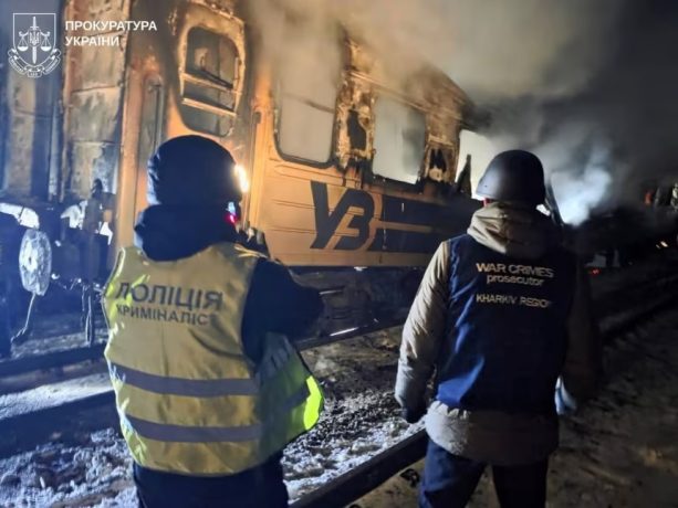 A war crimes prosecutor and a police officer work next to a passenger train hit by a Russian drone strike in Kharkiv on January 27, 2026.