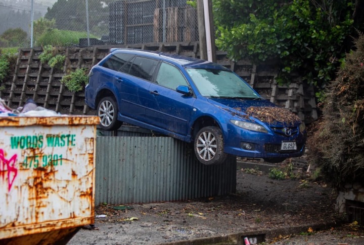 A-car-carried-by-floodwaters-landed-on-top-of-a-chest-high-fence-after-Mondays-torrential-rain-in-Wellington