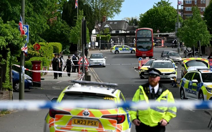 Police officers work by cordon at the junction of Golders Green Road and the North Circular Road, in the Golders Green neighbourhood of north London, on April 29, 2026, after two people were stabbed, and a suspect arrested.