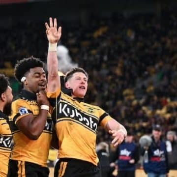 Hurricanes players from left, Winger Fehi Fineanganofo, No.8 Peter Lakai and halfback Cam Roigard celebrate after a lightning-fast start against the Blues. Roigard's early try helped spark Wellington's charge into the Super Rugby Pacific Grand Final.