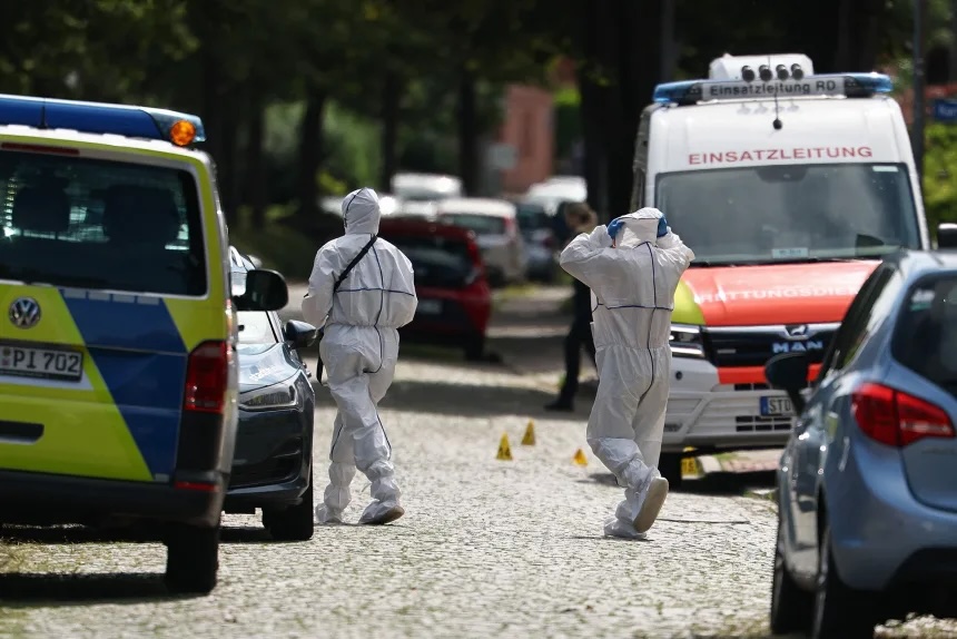 Forensic police officers work near the scene where six people were killed in a shooting in Stade, northern Germany on Monday.