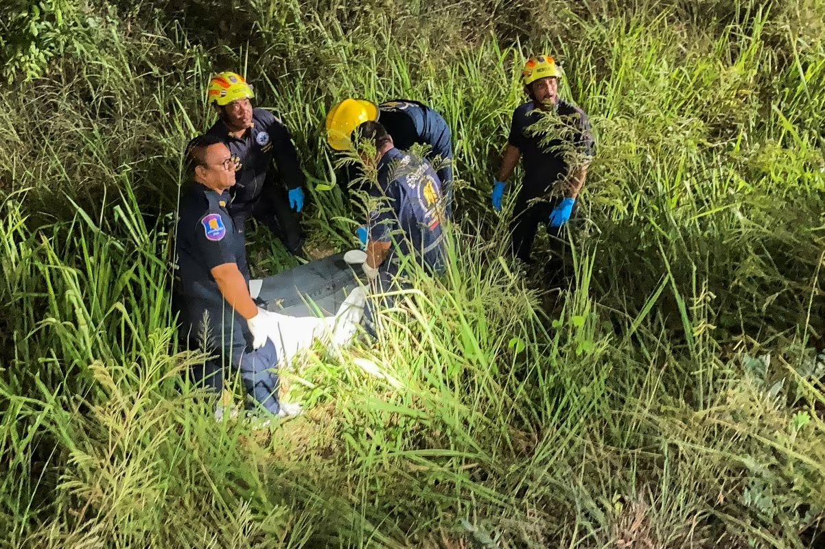 Rescue workers recover a suitcase from a grassy area near a railway track, in which police later found the body of a 17-year-old Thai girl, in Pattaya City, Thailand, on June 27, 2026.