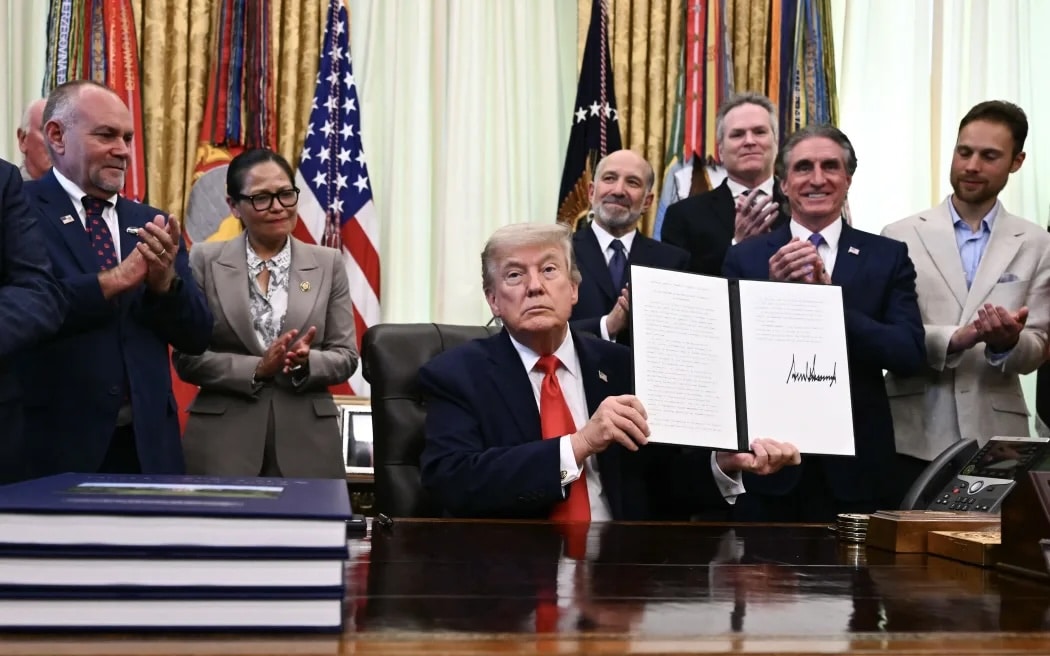 US President Donald Trump displays a proclamation on "returning American commercial fishing in the Pacific" in the Oval Office of the White House in Washington, DC, on 11 June 2026.