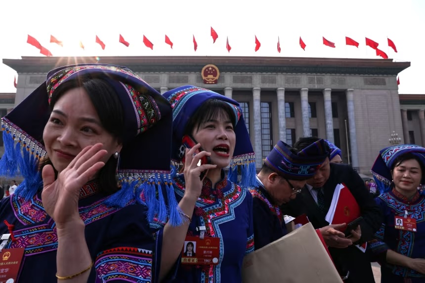 Legislative delegates in ethnic minority dress exit the closing session of the National People's Congress at Beijing's Great Hall of the People on March 12.