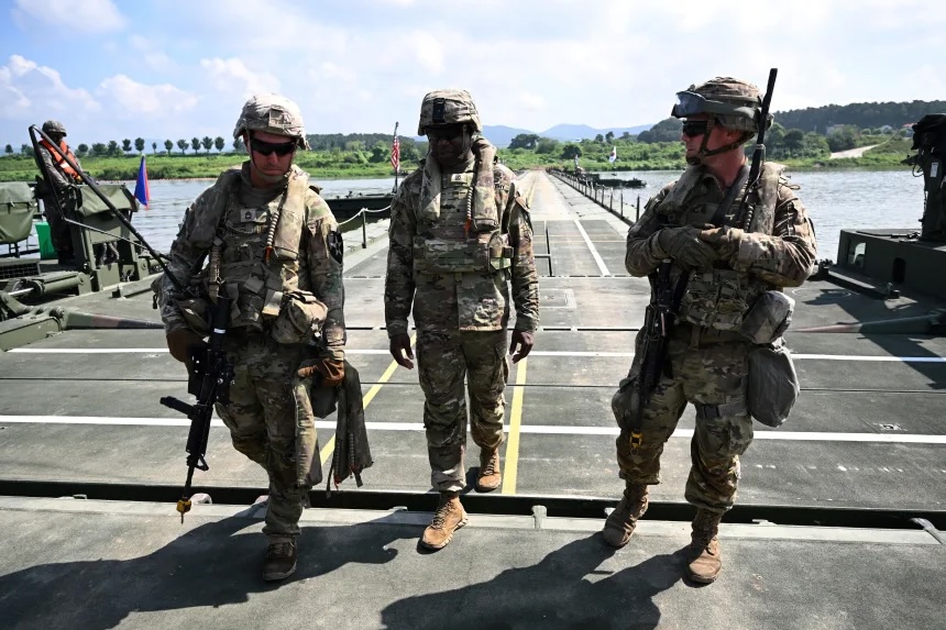 US soldiers walk on a floating bridge during a South Korea-US joint river-crossing drill as part of the annual Ulchi Freedom Shield military exercise in Yeoju on August 27, 2025.