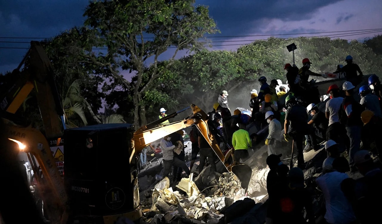 Rescuers and volunteers search for survivors amid the rubble of a collapsed building after an earthquake in Cali, Colombia on August 11.