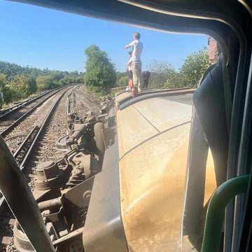 People stand on an overturned train carriage after the derailment in Lewes on Thursday afternoon.